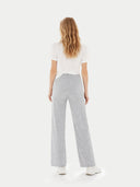 Back view of a woman wearing light gray pants and a white top on a white background #color_high-rise