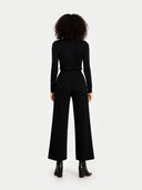 back view of a person wearing a black jumpsuit on a white background  #color_black