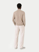 back view of a Person wearing a beige sweater and light-colored pants on a white background #color_taupe