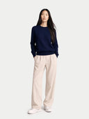 front view of person wearing a navy sweater and beige pants on a white background color_mood-indigo