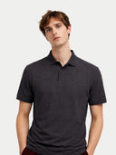 Man wearing a dark gray polo shirt against a light gray background #color_charcoal