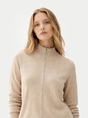 Woman wearing a beige zip-up sweater on a light gray background #color_warm-grey