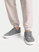 Gray sneakers worn with light-colored pants on a white background #color_stone-gray