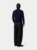 Back view of a person wearing a navy sweater and black pants on a white background #color_navy-blazer