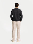 back view of a Man wearing a dark gray sweater and beige pants on a light gray background #color_charcoal