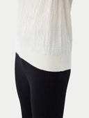 close up bottom side of a white t-shirt and black pants #color_whisper-white