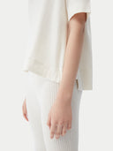 close up bottom side of a white short sleeve top and white ribbed pants #color_whisper-white