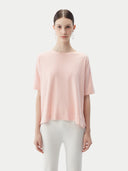 A woman wearing a pink box-cut t-shirt made from a blend of cotton, silk, and cashmere. #color_primrose-pink