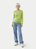 front view of Person wearing a green sweater and blue jeans on a white background #color_jade-lime