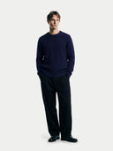 Man wearing a navy sweater and black pants on a white background #color_navy