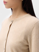Close-up of a beige cardigan worn by a person on a light gray background #color_beige