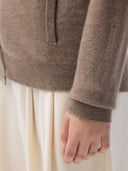 Close-up of a brown sweater with a person wearing it, on a light background  #color_taupe