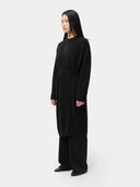 Person wearing a long black dress on a white background #color_black