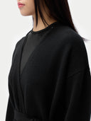 Person wearing a black outfit against a white background #color_black