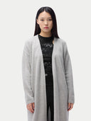 Woman wearing a long gray cardigan over a black outfit on a white background. #color_dawn-blue