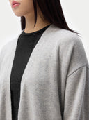 Person wearing a gray cardigan over a black top on a white background. #color_dawn-blue