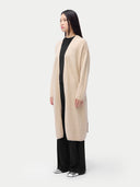 Woman wearing a beige cardigan over a black outfit on a white background #color_beige