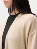 close up of a beige cardigan with black stripe worn by a person. #color_beige