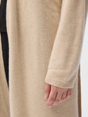 Close-up of a beige cardigan with a hand visible. #color_beige