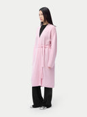 Person wearing a pink coat on a plain background #color_almond-blossom
