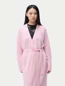 Woman wearing a pink robe against a plain background #color_almond-blossom