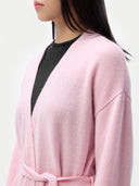 Person wearing a pink robe with a black top. #color_almond-blossom