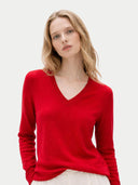 Woman wearing a red v neck sweater on a white background #color_chili-pepper