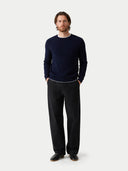 Man wearing a navy sweater and black pants on a white background #color_navy-blazer