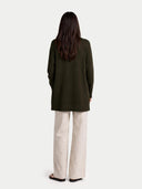 back view of a person wearing a dark green coat and beige pants on a white background #color_avocado