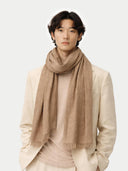 Man wearing a beige scarf and light-colored suit on a white background