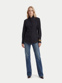Woman wearing a black blouse and blue jeans on a white background #color_black