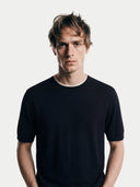 front view of a man wearing a black t-shirt against a white background #color_black
