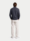 back view of a man wearing a dark gray sweater and light-colored pants on a white background #color_charcoal