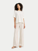 Woman wearing a white top and pants on a white background #color_whisper-white