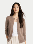 close up of a woman wearing a brown cardigan over a white top on a light gray background #color_taupe