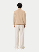 back view of Person wearing a beige sweater and white pants on a white background #color_beige
