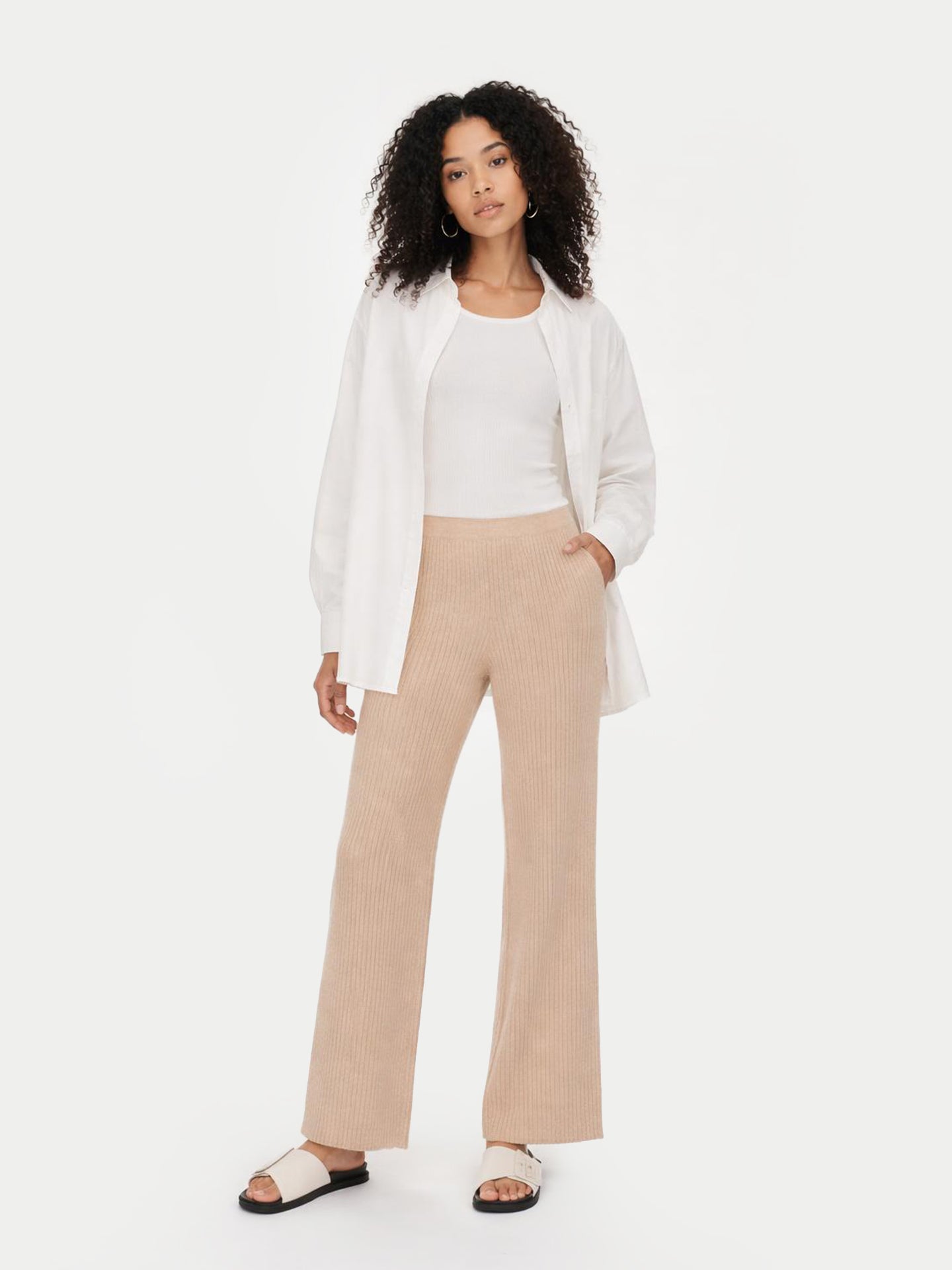 Woman wearing a white blazer and beige pants on a white background #color_beige