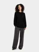Person wearing a black sweater and gray pants on a white background #color_blue-graphite