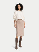 front view of a woman wearing a white sweater and beige skirt with brown knee-high boots on a white background #color_fog