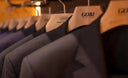 GOBI-branded wooden hangers holding dark cashmere coats on a rail