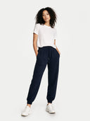 Woman wearing navy jogger pants and a white t-shirt on a white background #color_navy
