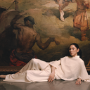 Woman in white cashmere sweater and hat set lounging in an art gallery — GOBI $99 Hat & Sweater Set