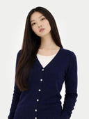 Woman wearing a navy blue v-neck cardigan over a white shirt on a white background #color_navy