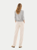 back view of a woman wearing a gray sweater and beige pants on a white background #color_high-rise
