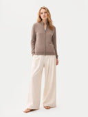 front view of a woman wearing a brown zip-up jacket and beige pants on a white background  #color_taupe