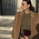 Woman wearing olive cashmere crewneck with camel coat — @GobiCashmere