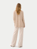back view of a woman wearing a beige open cardigan and beige pants on a white background #color_beige