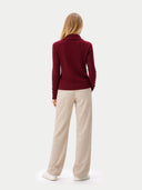 back view of a person wearing a burgundy sweater and beige pants on a white background #color_zinfandel