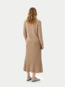 back view of woman wearing a beige sweater and ribbed skirt on a white background #color_warm-grey