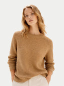Woman wearing a brown sweater on a light gray background #color_almond